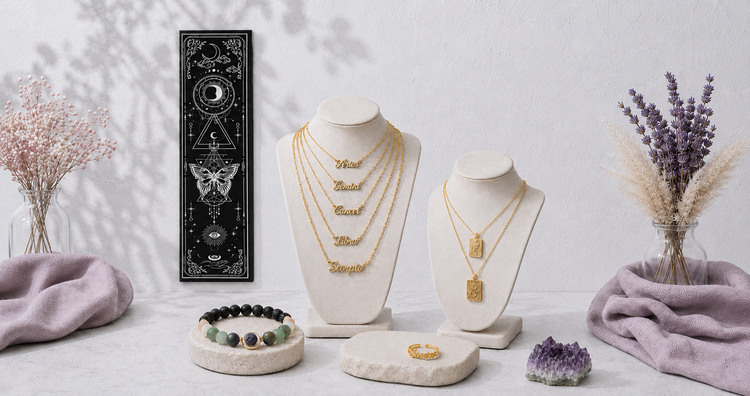 Astrology jewelry and wearables collection featuring layered zodiac name necklaces, celestial pendant necklaces, a gemstone diffuser bracelet, and a hanging moon phase wall tapestry in a soft botanical studio setting. — for Carpe Diem Dream