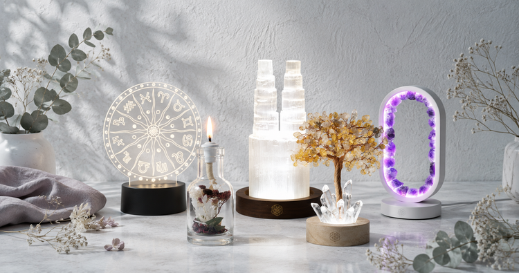 Candles and ambient lighting collection featuring a citrine crystal tree lamp, selenite tower lamp, amethyst portal lamp, Balance candle, and botanical oil candle in a bright CDD Studio Botanical setting. — for Carpe Diem Dream