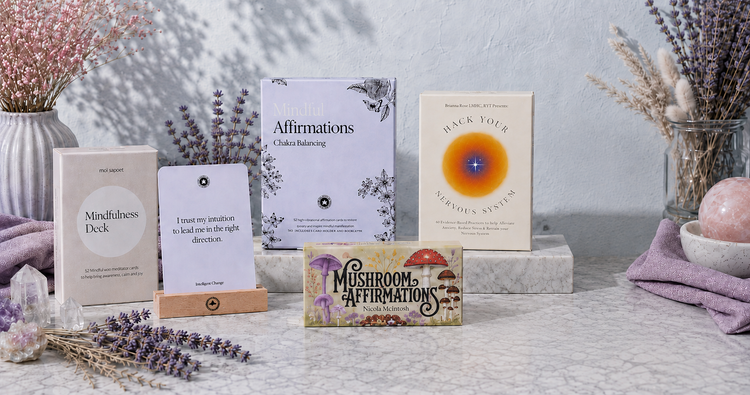 Cards & Decks collection featuring mindfulness, affirmation, chakra-balancing, nervous-system, and mushroom affirmation decks in a cool botanical setting — for Carpe Diem Dream