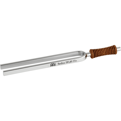 Single metal tuning fork with cork handle engraved Sedna 181.60 Hz shown on a white background. — for Carpe Diem Dream