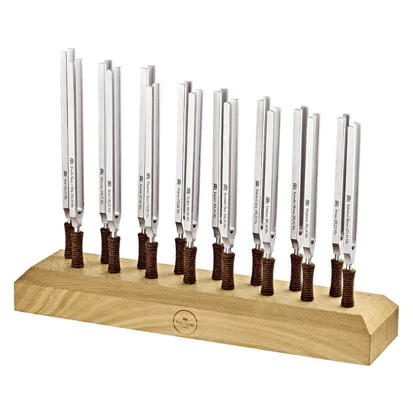 Sixteen metal tuning forks with cork handles arranged upright in a wooden display stand on a transparent background. — for Carpe Diem Dream