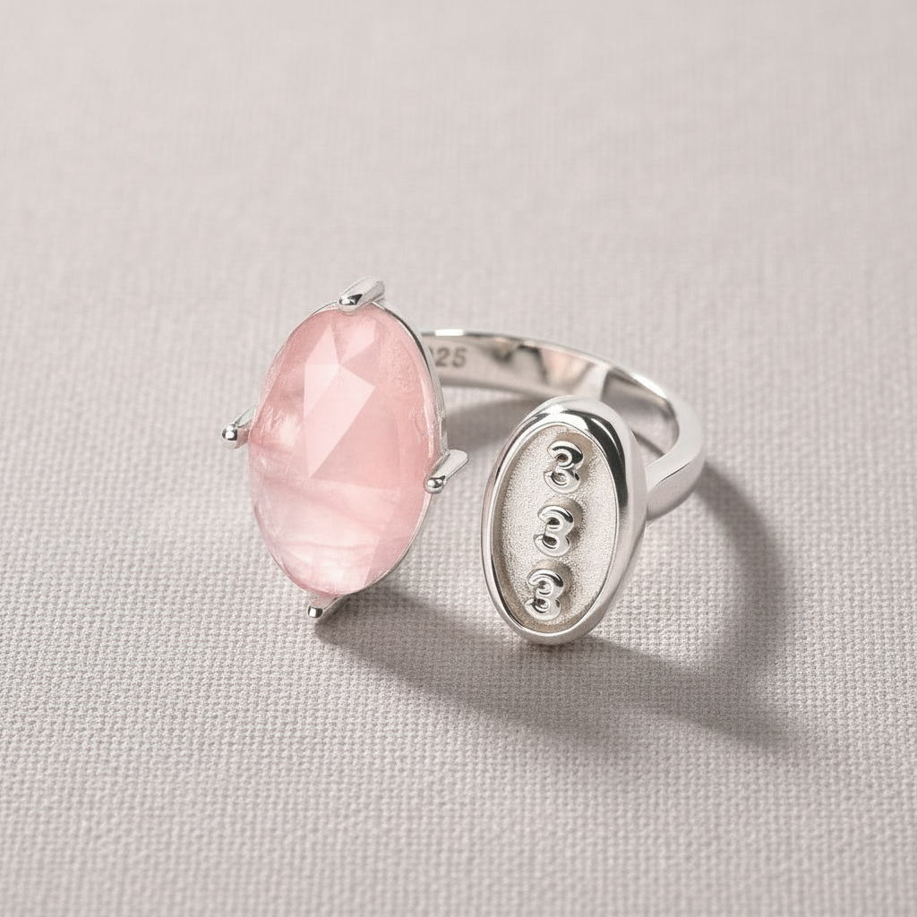 Rose quartz and silver angel number 333 ring displayed on a soft neutral fabric backdrop. — for Carpe Diem Dream