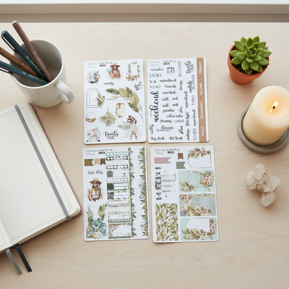 Four 4x6 boho chic happy planner matte sticker sheets arranged on a light wood desk with a lit candle, crystal cluster, notebook, and small succulent. — for Carpe Diem Dream