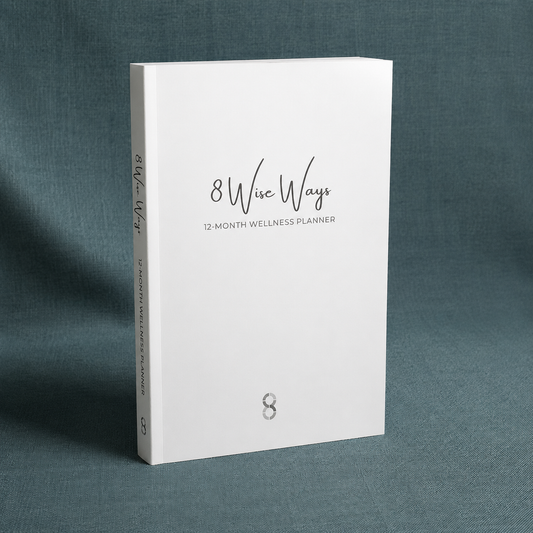 8 Wise Ways 12-Month Wellness Planner displayed upright on a teal-grey linen background with soft diffused lighting, designed to support wellbeing, reflection, healthy habits, and personal growth. — for Carpe Diem Dream