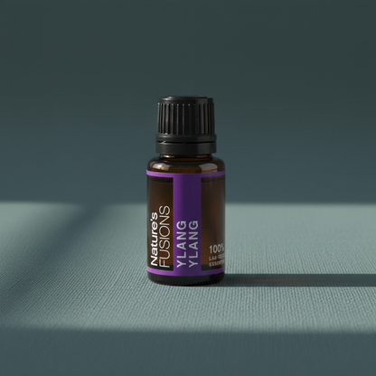 A 15ml amber glass bottle of Ylang Ylang essential oil with a black cap and purple label displayed on a muted teal linen surface with soft natural light. — for Carpe Diem Dream