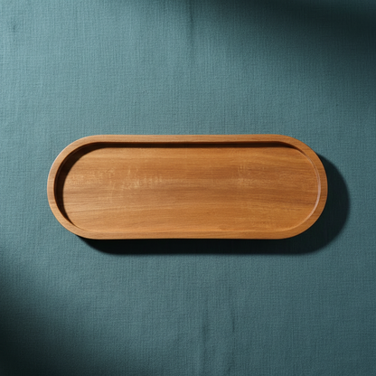 Acacia wood oval tray displayed on deep teal textured linen with soft directional lighting and grounded shadowing. — for Carpe Diem Dream