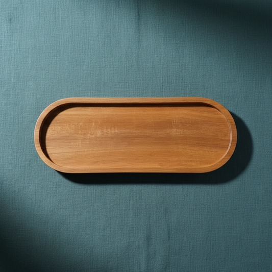 Acacia wood oval tray displayed on deep teal textured linen with soft directional lighting and grounded shadowing. — for Carpe Diem Dream