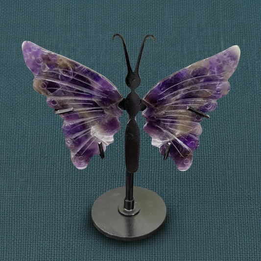 Amethyst crystal butterfly wings on a black stand displayed upright on a deep teal linen background with soft diffused lighting. — for Carpe Diem Dream