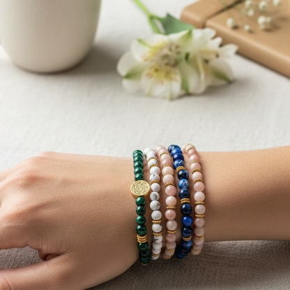Multicolored love bracelets stacked on wrist beside neutral coffee mug and flower. — for Carpe Diem Dream
