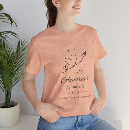 Model wearing a Heather Peach Aquarius Rising I Innovate zodiac T-shirt with black celestial heart and arrow artwork. — for Carpe Diem Dream