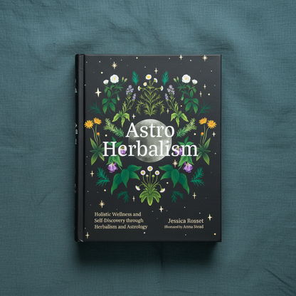 Astro Herbalism by Jessica Rosset displayed upright on a textured teal linen background highlighting the botanical cover artwork. — for Carpe Diem Dream