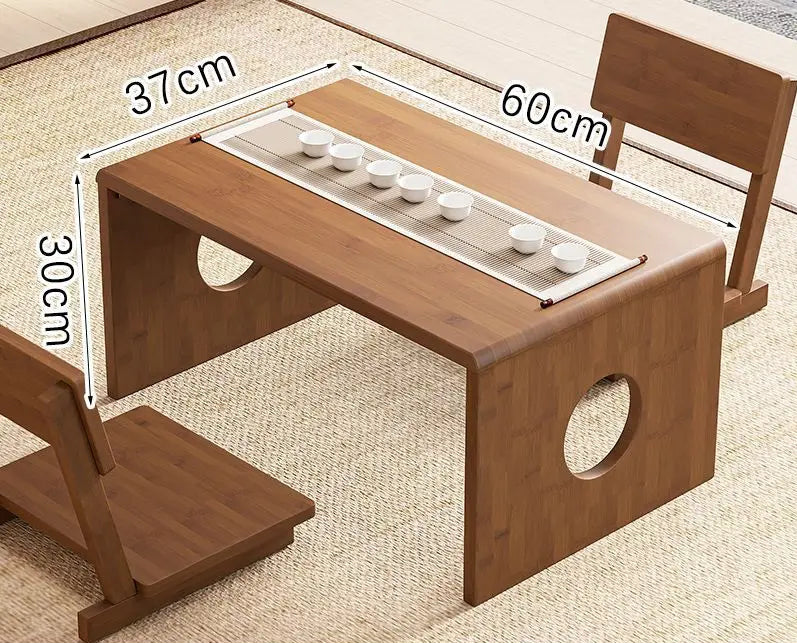 A bamboo folding table in a 60cm size displayed on a woven floor surface with a tea setup, highlighting its compact design and natural finish. — for Carpe Diem Dream