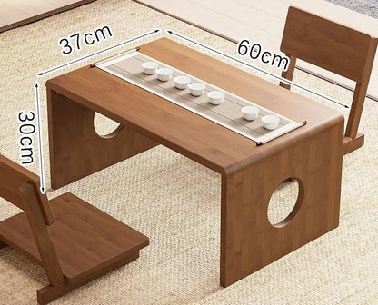 A bamboo folding table in a 60cm size displayed on a woven floor surface with a tea setup, highlighting its compact design and natural finish. — for Carpe Diem Dream