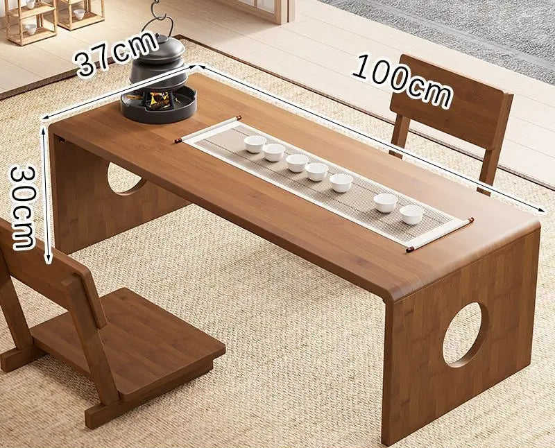A bamboo folding table in 100cm size displayed in a natural interior setting with a tea setup, showing its larger surface area and low-profile design. — for Carpe Diem Dream
