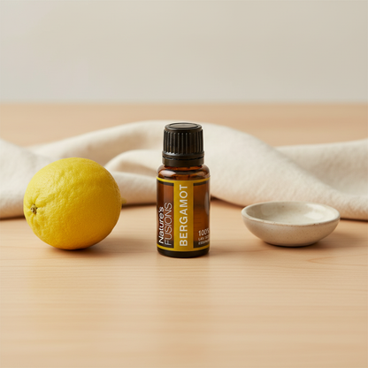 A 15ml amber glass bottle of Bergamot essential oil displayed on a wooden surface beside a whole lemon and a small ceramic bowl. — for Carpe Diem Dream