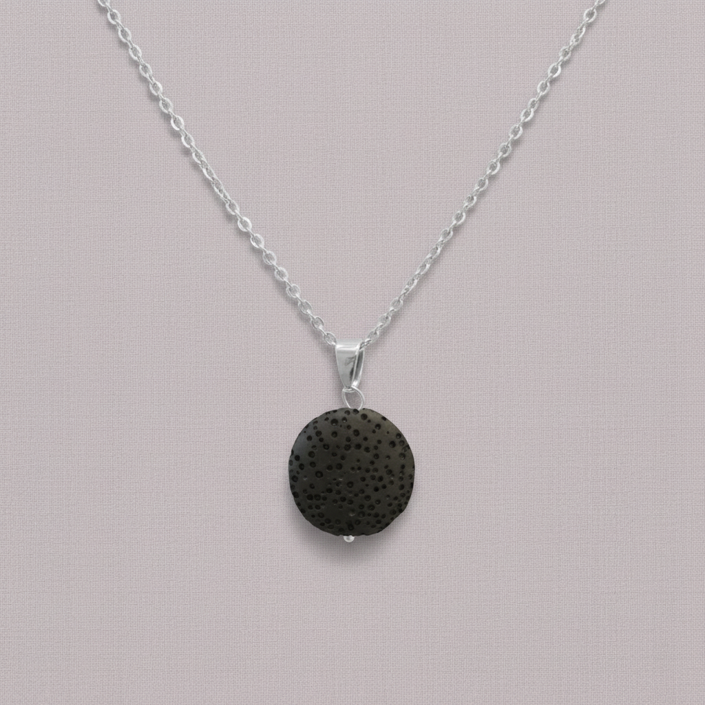 A round black lava stone essential oil necklace on a silver chain displayed against a soft neutral background. — for Carpe Diem Dream