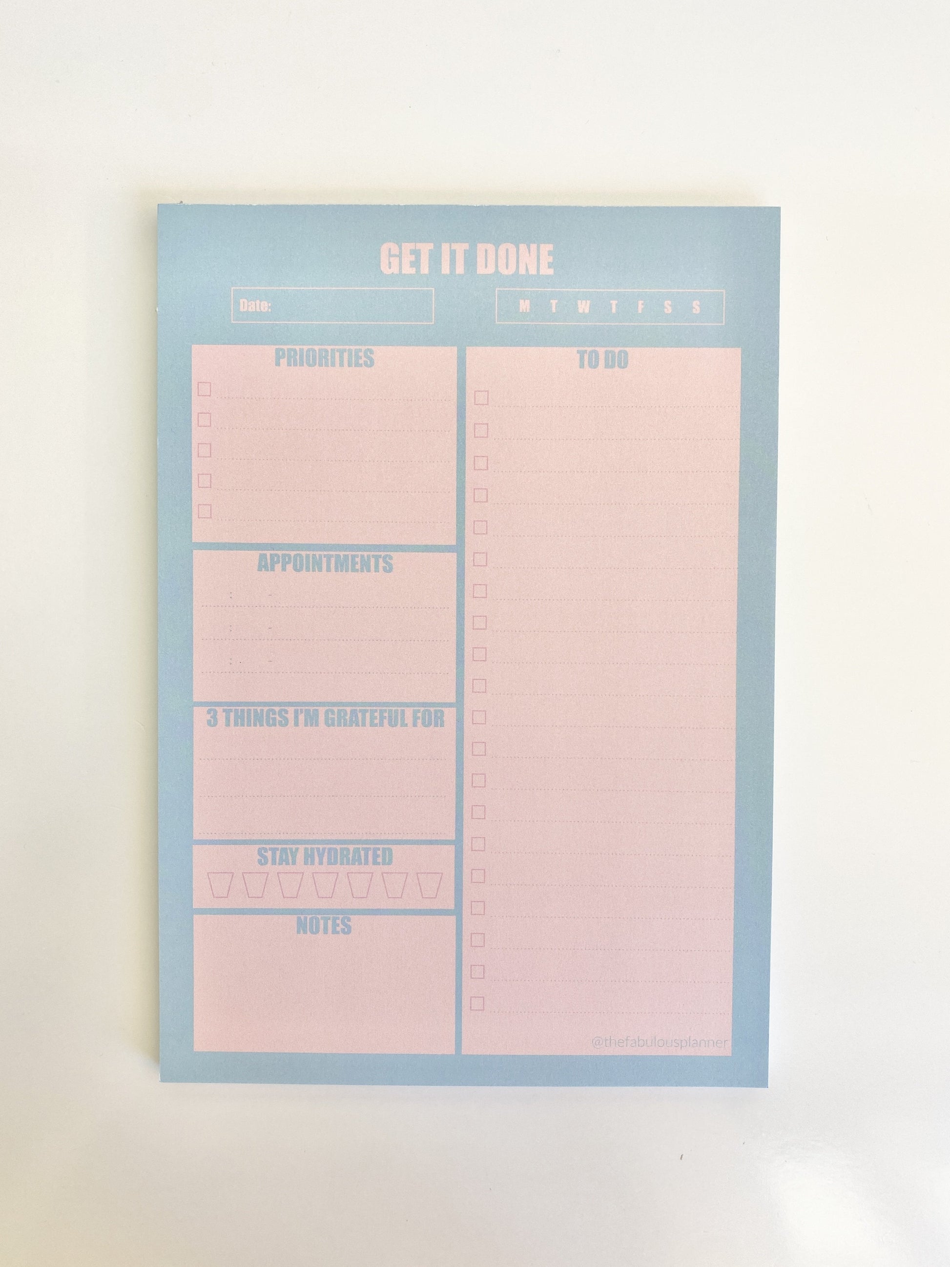 Blue and pink 7x10 daily planner notepad shown flat against a clean white background. — for Carpe Diem Dream