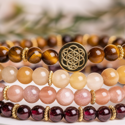 Close-up detail of stacked gemstone bracelets showing gold flower-of-life charm and polished bead textures. — for Carpe Diem Dream