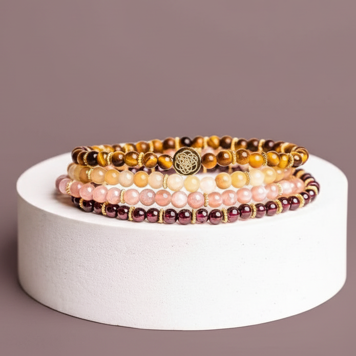 Stacked gemstone bracelet set displayed on a white travertine cylinder against a muted mauve backdrop. — for Carpe Diem Dream