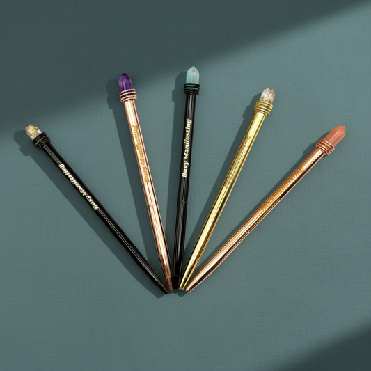 Metallic Busy Manifesting crystal mystic pen with faux crystal top displayed in a flat lay arrangement on a muted teal background — for Carpe Diem Dream