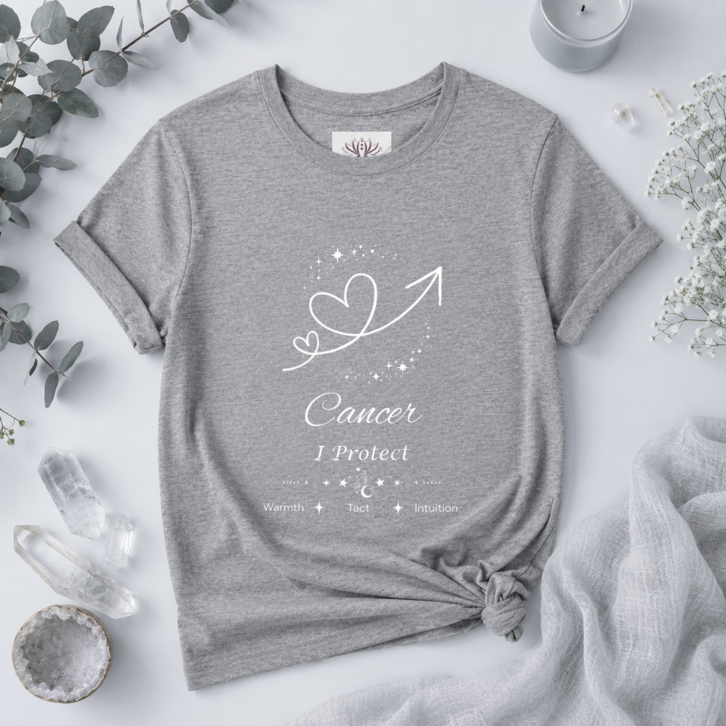 Cancer Rising I Protect zodiac T-shirt in Athletic Heather with white celestial heart and arrow artwork and Warmth, Tact, Intuition text, styled in a cool-toned studio botanical flat lay. — for Carpe Diem Dream