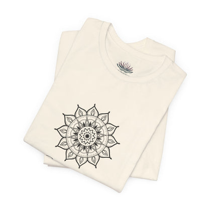 Capricorn Sun I Use zodiac T-shirt in natural with black sun-inspired mandala artwork, shown folded with Carpe Diem Dream neck label in a supplier mockup. — for Carpe Diem Dream