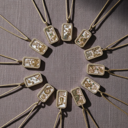 Multiple 18K gold zodiac pendant necklaces arranged in a circular layout on a mauve textured linen surface in soft natural light. — for Carpe Diem Dream