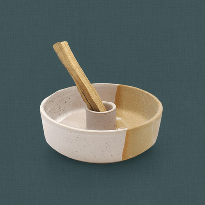 A ceramic palo santo burner with a smudge stick placed upright in the holder on a muted teal background. — for Carpe Diem Dream