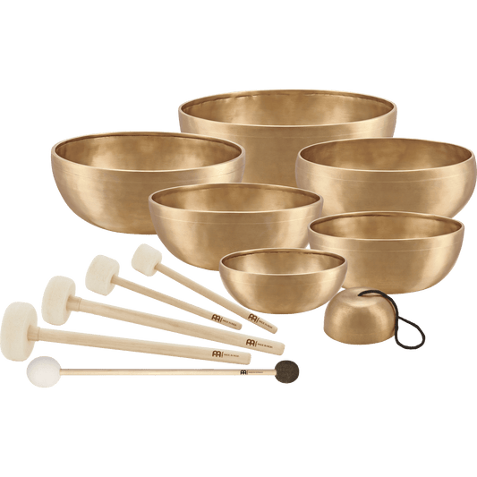 Seven handcrafted bronze singing bowls with five wooden-handled mallets, felt rings, and protective covers arranged as a complete chakra sound healing set on a transparent background. — for Carpe Diem Dream