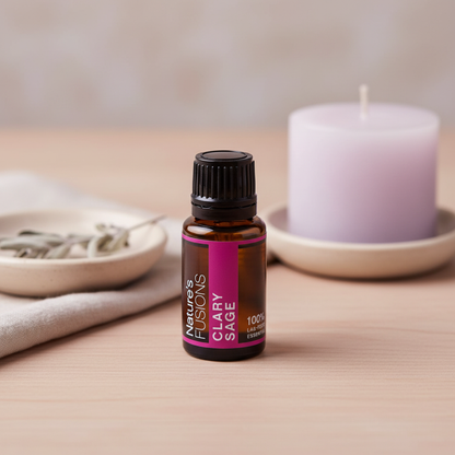 A 15ml amber glass bottle of Clary Sage essential oil placed on a wooden surface beside a white candle and a small dish with dried herbs. — for Carpe Diem Dream