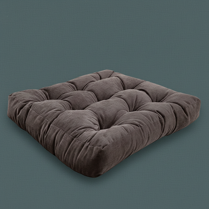 A thick corduroy floor cushion in a square tufted design shown in a rich brown tone on a muted teal background. — for Carpe Diem Dream