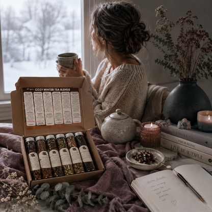 Cozy Winter Tea Sampler styled in a peaceful winter window ritual with tea, soft mauve textiles, a journal, and cool botanical accents. — for Carpe Diem Dream