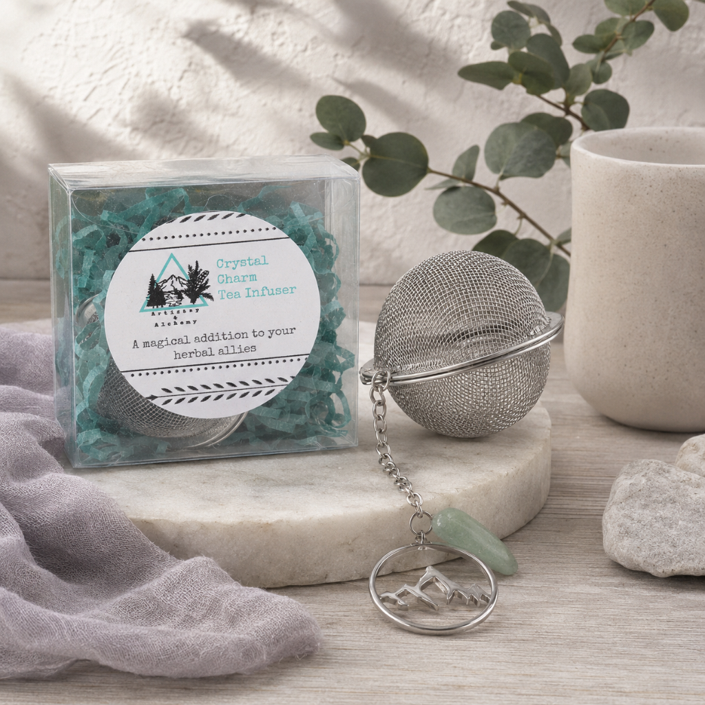 Crystal Charm Tea Infuser – authentic tea infuser displayed in the Carpe Diem Dream Botanical Studio with clear packaging, metal mesh strainer, crystal charm, Roman Clay textures, eucalyptus, matte ceramics, mauve linen, natural stone styling, and cool diffused daylight. — for Carpe Diem Dream