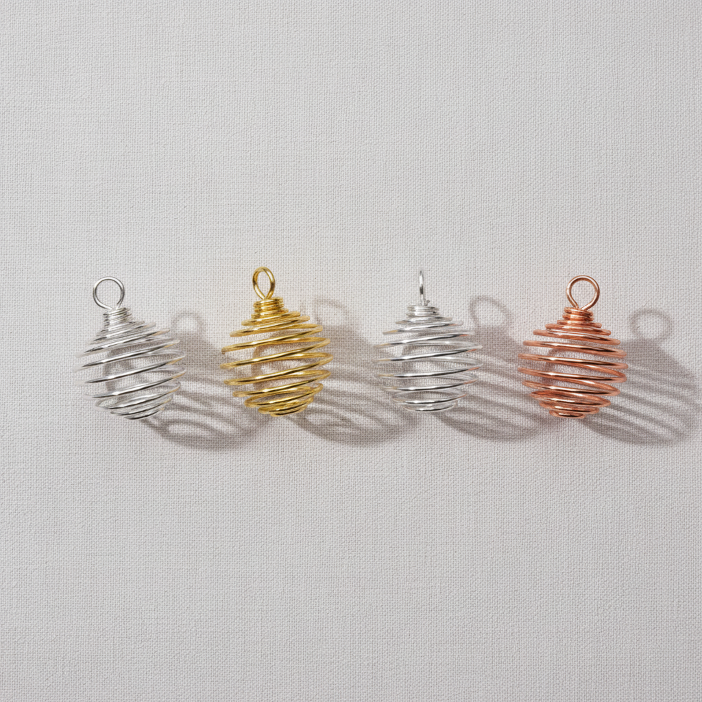 A set of silver, gold, and copper spiral crystal cage pendants displayed upright on a neutral textured background. — for Carpe Diem Dream