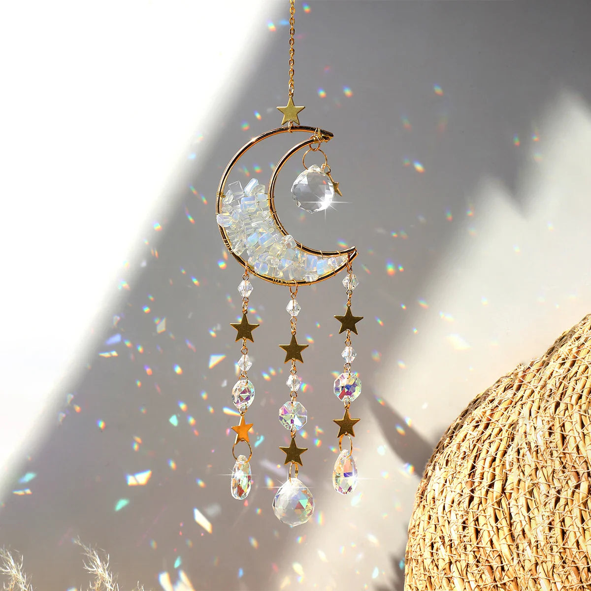 A clear quartz crystal moon suncatcher with a gold crescent frame and faceted prism drops, displayed in bright natural light showing its transparent stone chips and rainbow reflections. — for Carpe Diem Dream