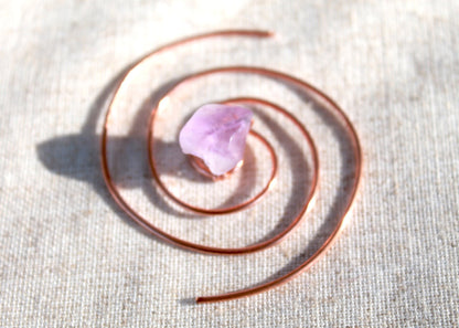 Amethyst copper spiral crystal water charger displayed on textured natural linen fabric. — for Carpe Diem Dream