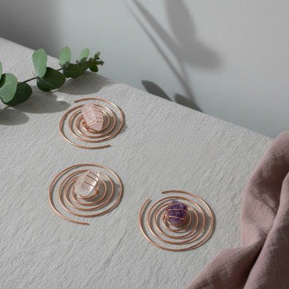 Copper spiral crystal water chargers with clear quartz, rose quartz, and amethyst displayed on textured ivory linen with eucalyptus and soft botanical shadows. — for Carpe Diem Dream