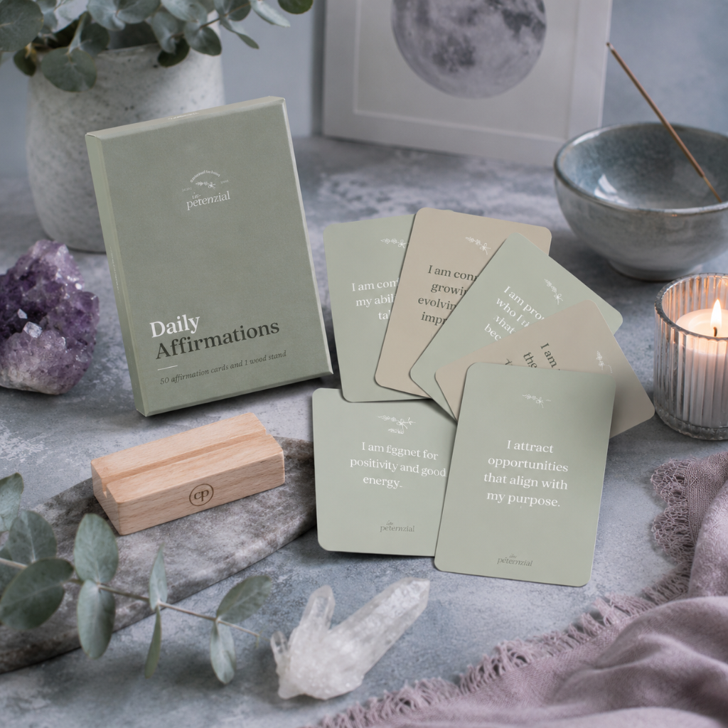Daily affirmation cards with wooden stand, crystals, eucalyptus, candle, and moon artwork in a cool-toned creative wellness setting — for Carpe Diem Dream.