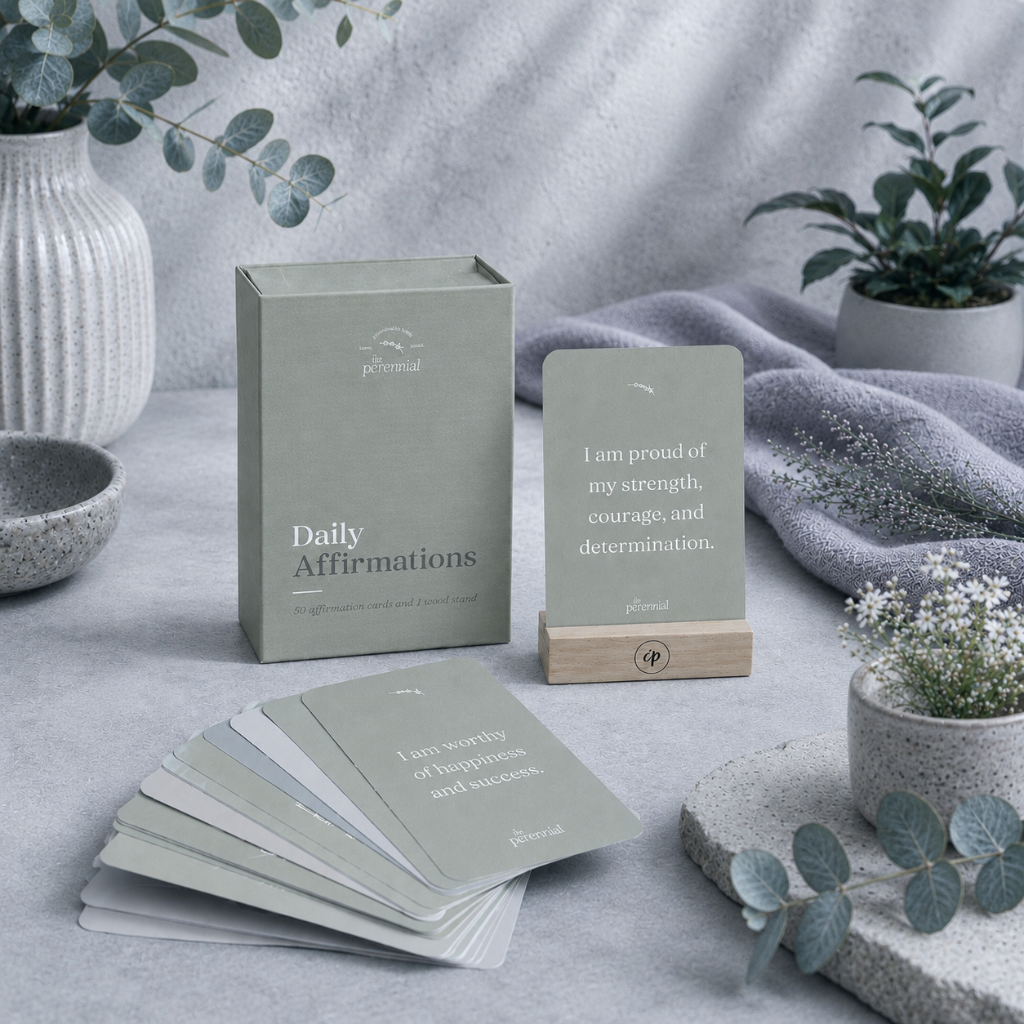 Daily affirmation cards with wooden stand and storage box in a cool-toned studio botanical setting with eucalyptus, soft mauve textile, and ceramic accents — for Carpe Diem Dream.