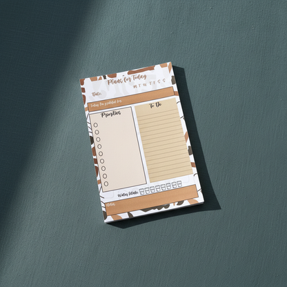 Minimalist 4x6 daily planning sticky notepad with priority, to-do, water intake, and gratitude sections displayed upright on a muted teal textured background. — for Carpe Diem Dream