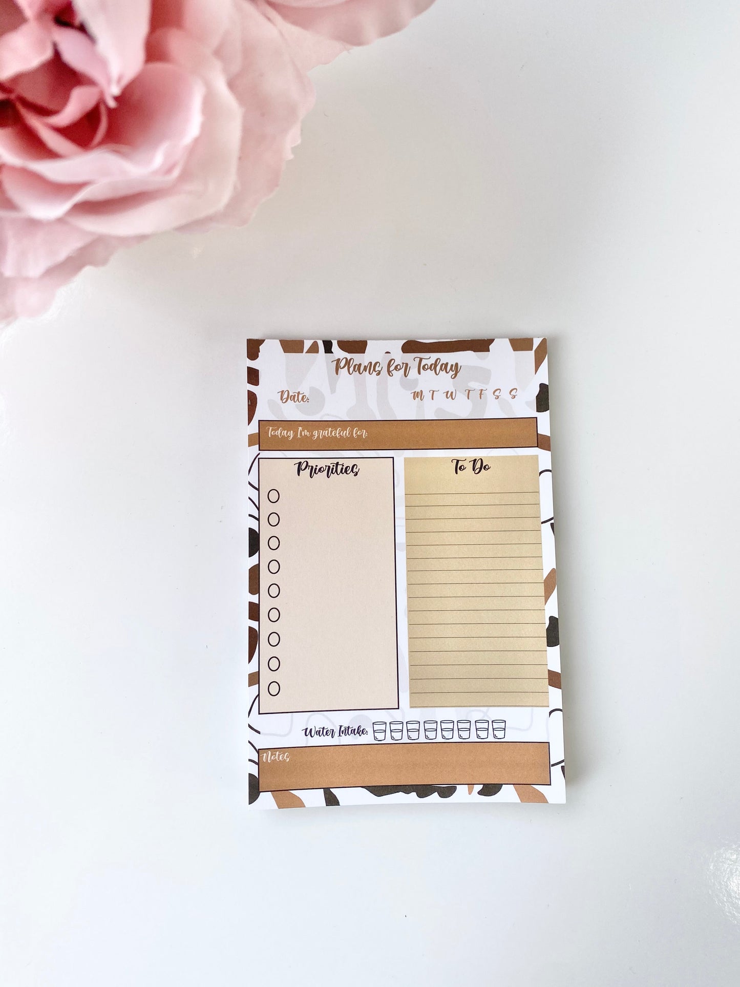 Minimalist 4x6 daily planning sticky notepad with priorities, to-do list, water intake, and gratitude sections on a clean white background with a pink flower accent. — for Carpe Diem Dream