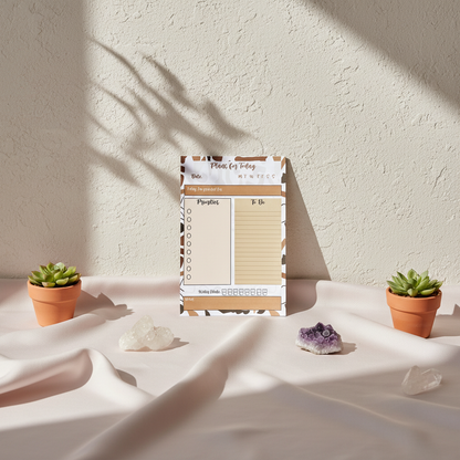 Minimalist 4x6 daily planning sticky notepad with priority and checklist sections displayed upright on draped fabric with small potted plants and crystals in soft natural light. — for Carpe Diem Dream