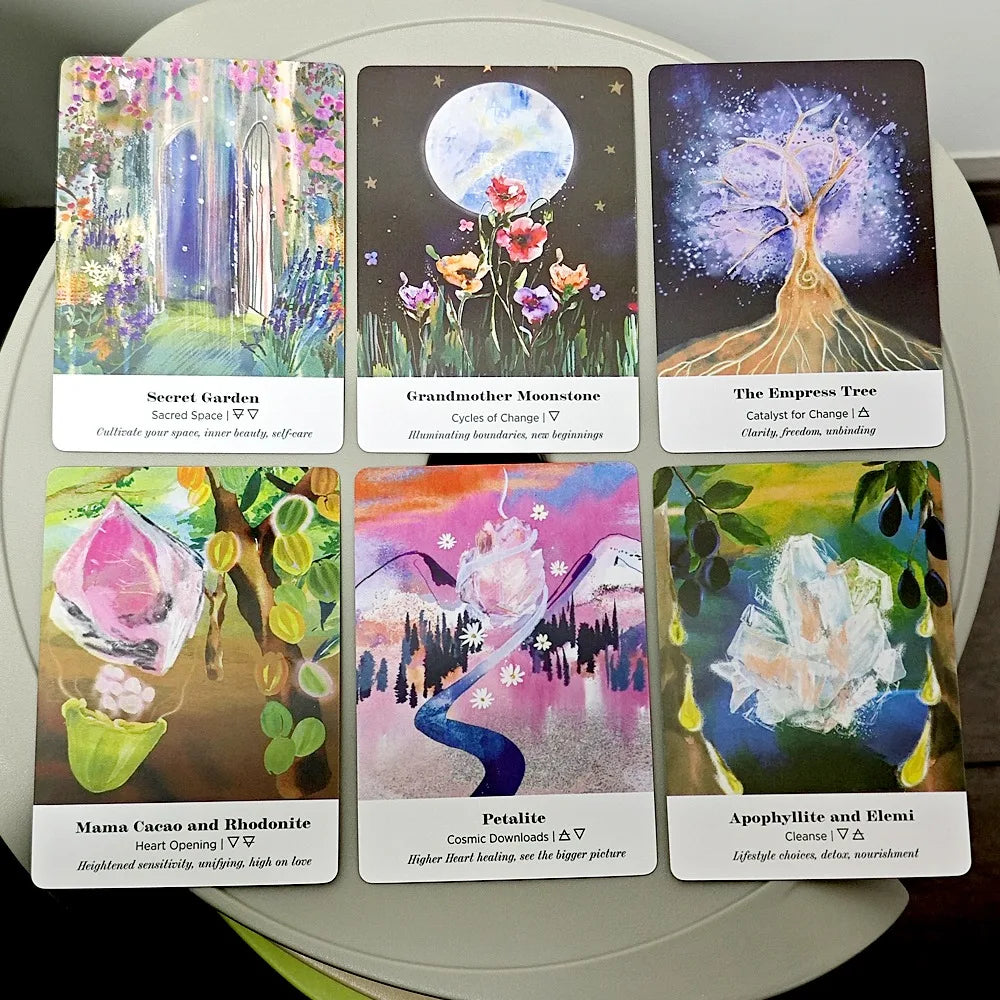 Six Earth Alchemy Oracle cards with colorful illustrated artwork are displayed in two rows on a neutral surface, showing detailed card designs. — for Carpe Diem Dream