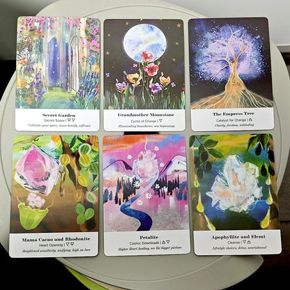 Six Earth Alchemy Oracle cards with colorful illustrated artwork are displayed in two rows on a neutral surface, showing detailed card designs. — for Carpe Diem Dream