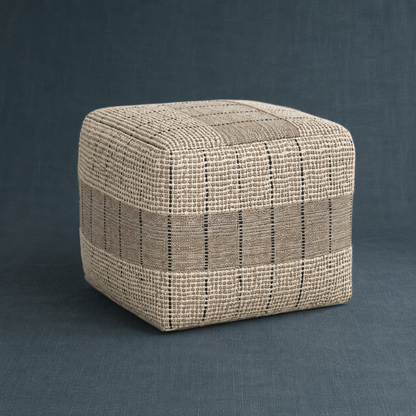 Elmer handwoven jute and cotton square pouf in natural and gray displayed against a dark teal studio backdrop. — for Carpe Diem Dream