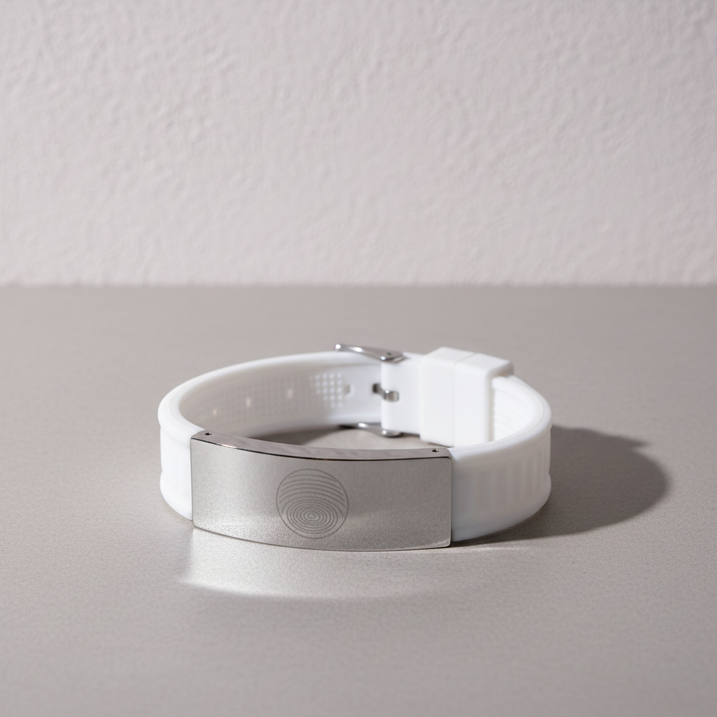 White EMF defense bracelet with stainless steel plate displayed on a clean neutral surface against a softly textured wall with gentle natural lighting and shadow. — for Carpe Diem Dream