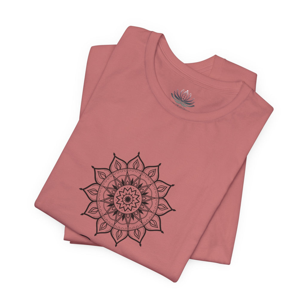 Gemini Sun I Think zodiac T-shirt in mauve with black sun-inspired mandala artwork, shown folded with Carpe Diem Dream neck label in a supplier mockup. — for Carpe Diem Dream