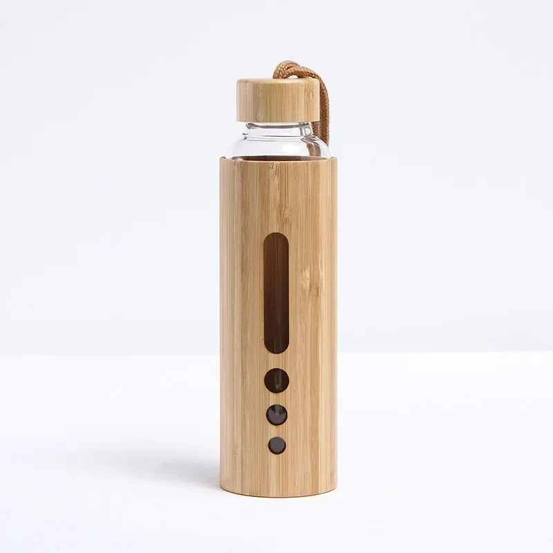 A bamboo glass water bottle with a window sleeve in the narrow design displayed upright on a white background. — for Carpe Diem Dream