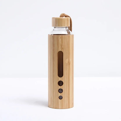 A bamboo glass water bottle with a window sleeve in the narrow design displayed upright on a white background. — for Carpe Diem Dream