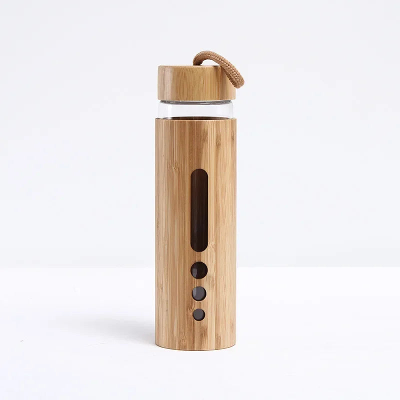 A bamboo glass water bottle with a window sleeve in the wide design displayed upright on a white background. — for Carpe Diem Dream